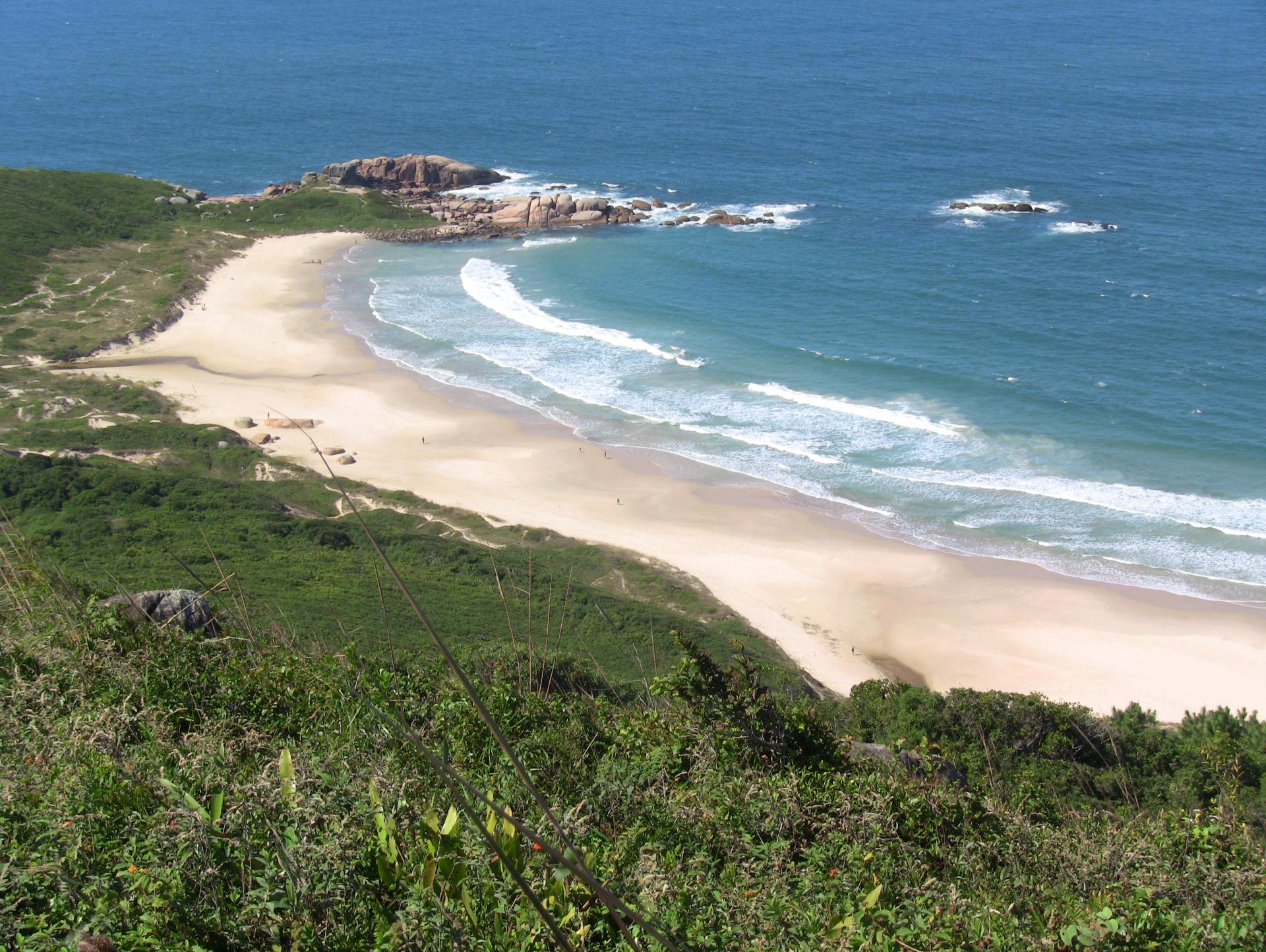 Lagoinha do Leste – Versteckter Strand in Florianópolis Luftaufnahme des abgelegenen Lagoinha do Leste Strandes in Florianópolis, Brasilien. Feiner weißer Sand, Wellen des Atlantiks und grüne Hügel im Hintergrund.