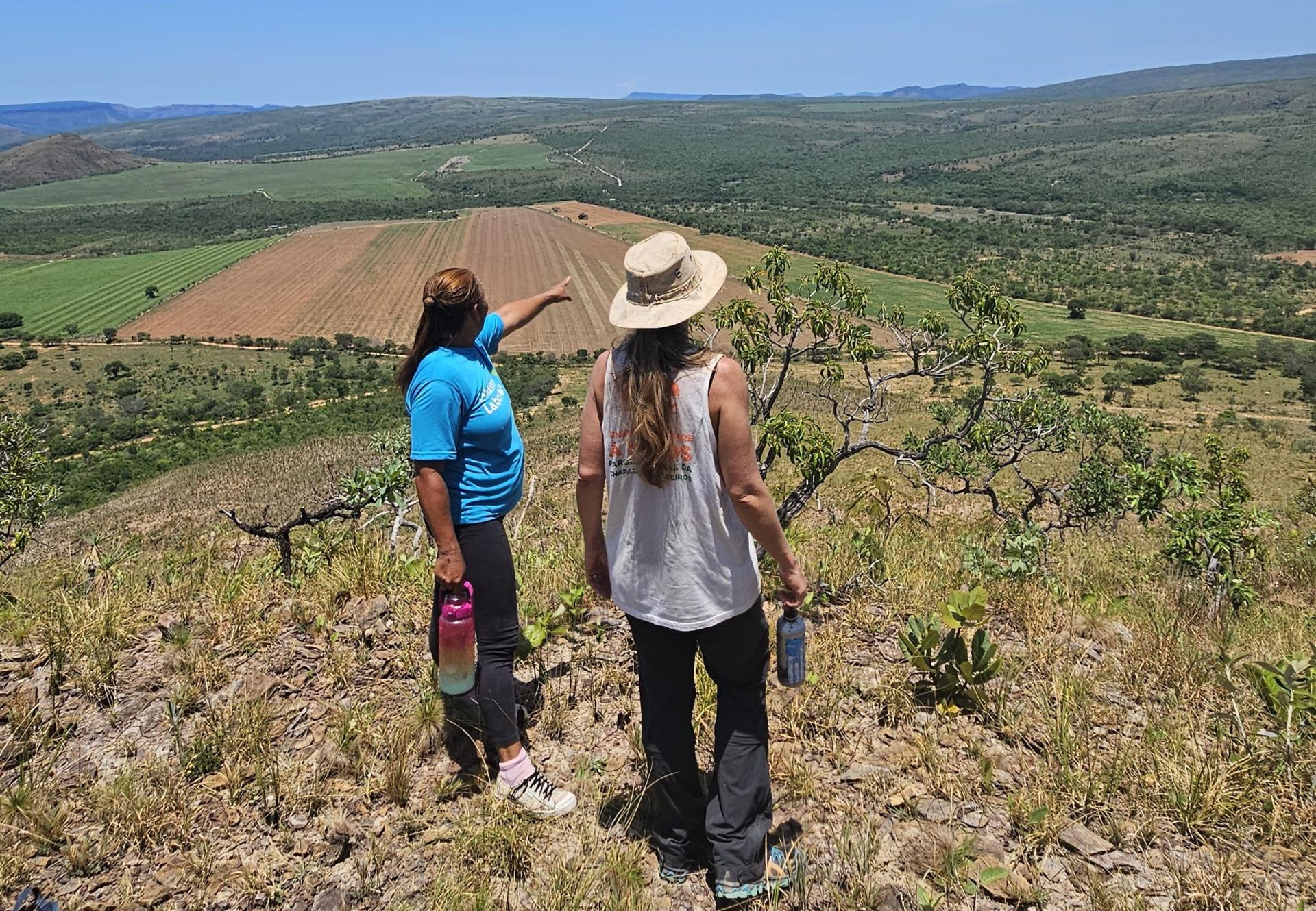 Zwei Fraue blicken vom Morro da Pirâmide auf die grüne Landschaft der Chapada dos Veadeiros – nachhaltiger Tourismus in Brasilien