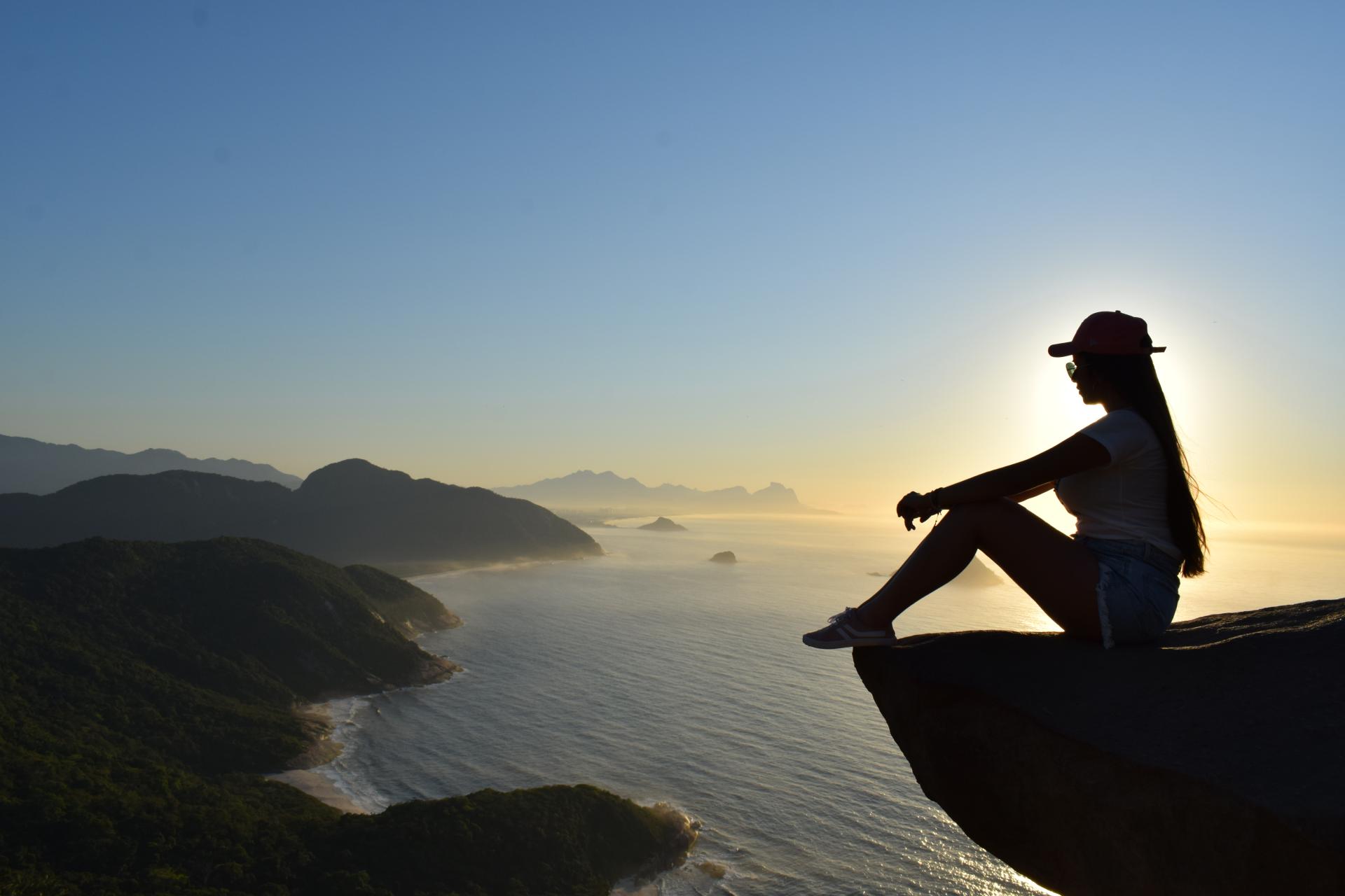 Aussicht vom Pedra do Telégrafo bei Sonnenaufgang in Rio Frau sitzt im Sonnenaufgang auf dem Pedra do Telégrafo mit Blick auf die Küste von Rio de Janeiro