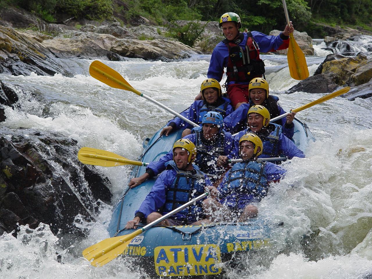 Adrenalin pur: Wildwasser-Rafting-Abenteuer in Brasilien Gruppe beim Wildwasser-Rafting in Brasilien in einem Schlauchboot mit Helmen und Paddeln, umgeben von spritzendem Wasser und Felsen