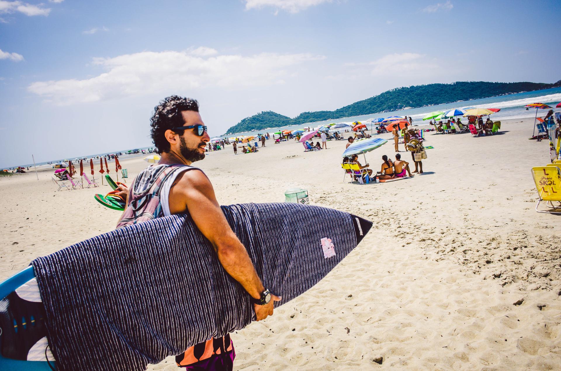 Surfer am Strand von Campeche, Florianópolis – idealer Surfspot für Anfänger Surfer mit Surfbrett am Strand von Campeche in Florianópolis, Brasilien an einem sonniger Tag mit lebendiger Strandatmosphäre.