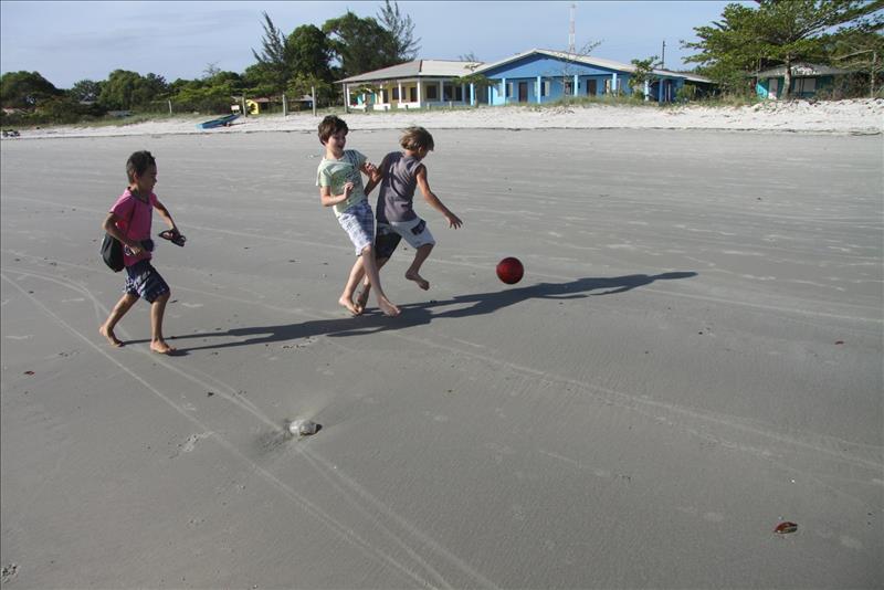 Brasilien ist auf den dritten Platz der FIFA Weltrangliste aufgestiegen Fußballspielende Kinder an brasilianischem Strand