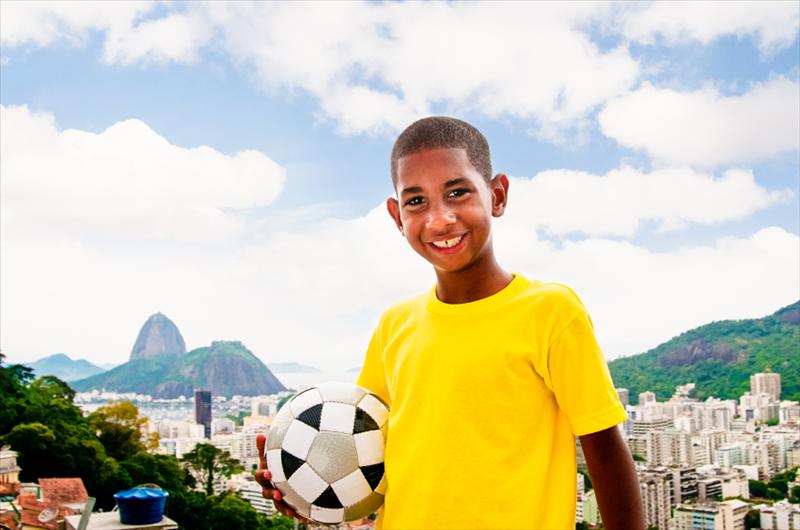 Die größte Sportveranstaltung des Jahres in Brasilien rückt näher Junge mit Fußball in Rio de Janeiro