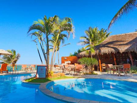 Ein Foto mit einem blauen Pool umgeben von Palmen im Hotel Manary Praia Pool