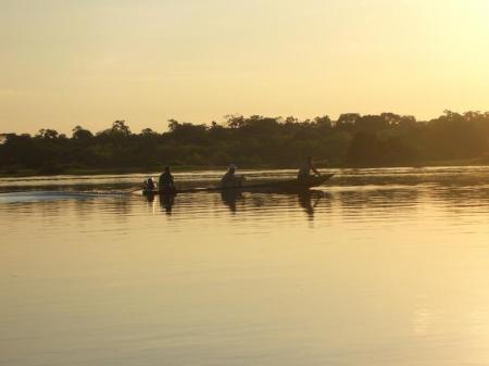 Motorkanu auf einem Fluss im Abendlicht im Amazonas-Regenwald