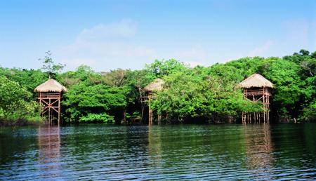 Hütten der Juma Amazon Lodge mit Blick auf den See