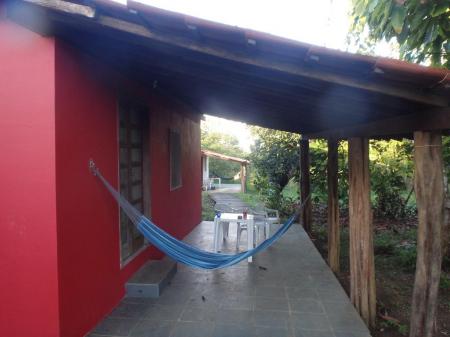 Ein rotes Bungalow mit Hängematte in der Pousada Fazenda Rio Negro