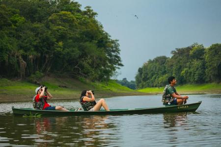 Uakari Lodge drei Menschen bei Kanutour auf dem Fluss