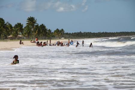 Menschen in der Brandung am Pratigi-Strand