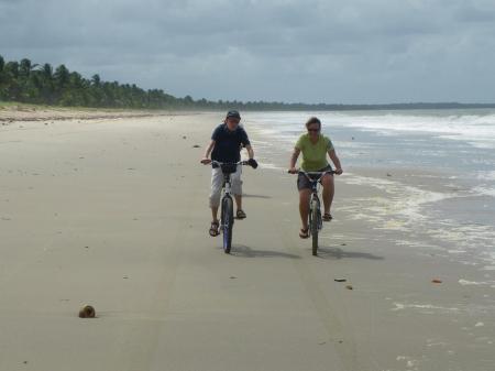 Zwei Radler fahren am Strand