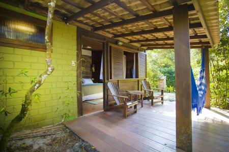 Ein Holzbungalow mit Hängematte im Grajagan Surf Resort auf der Ilha do Mel