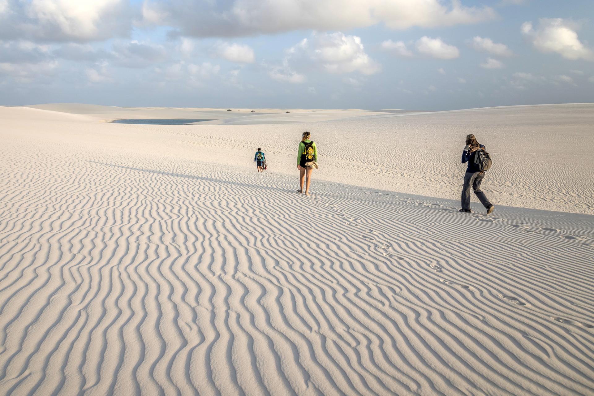 Drei Reisende unterwegs in einer Dünenlandschaft in Brasilien